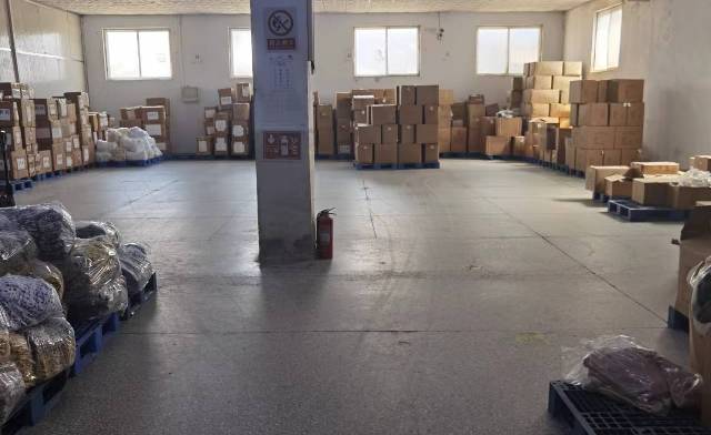 荣岛检品车间二组，检品员整理并检查叠装服装